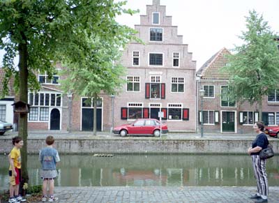 Martin, Adrian and Miriam standing by a canal with traditional Dutch buildings in the background