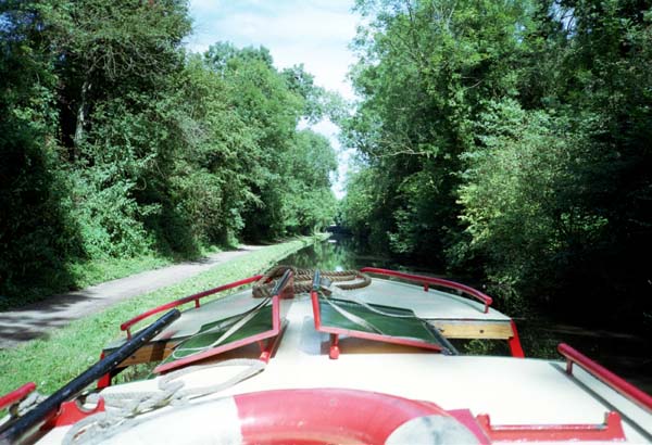 Looking forward over the roof of a barge along a canal