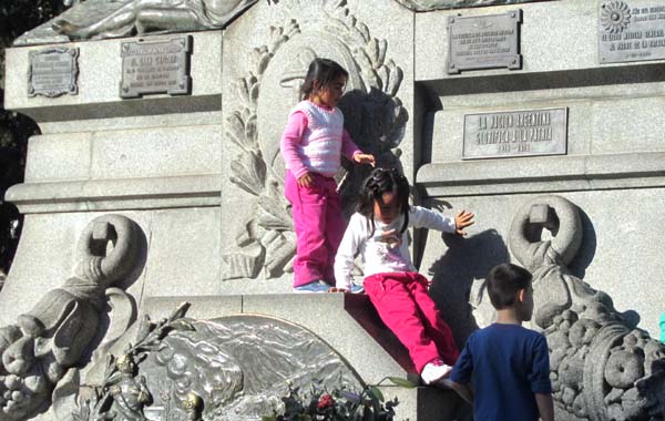 Children playing around the statue in the centre of Plaza San Martín, Córdoba, Argentina