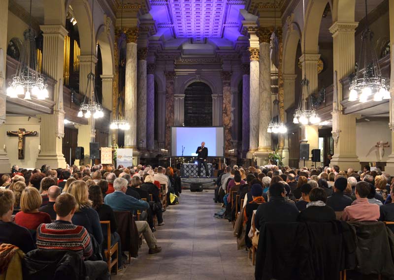 Andy Kind performing before a large audience in the Cathedral