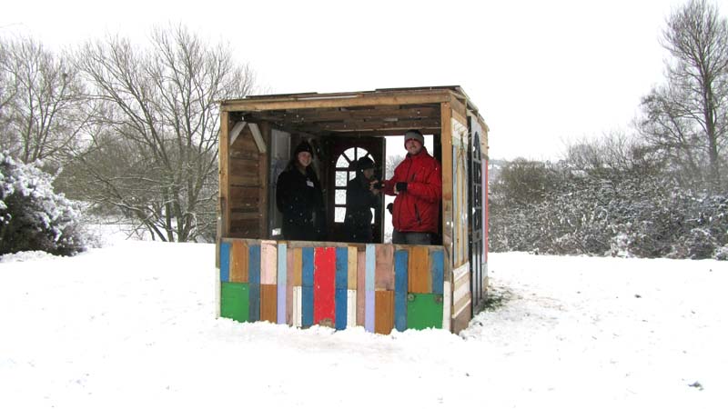 A multicoloured shed construction in a snowy landscape