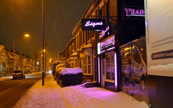 Pink lights from a shop on snow-covered Pershore Road