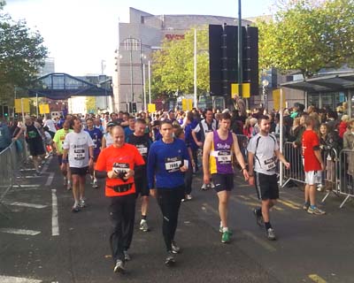 Runners walking along a sunlit street