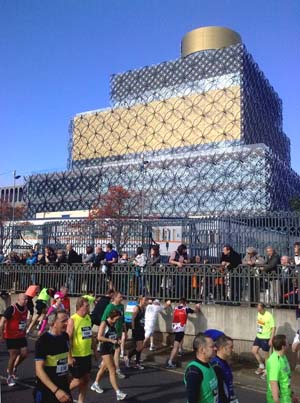 Runners walking with a new, modern building in the background