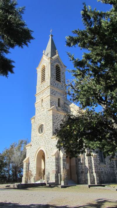 A church tower among trees against a blue sky