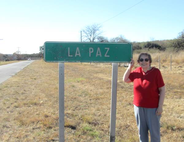 Miriam standing next to a road sign for La Paz