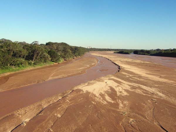 A narrow stream running along a wide river bed