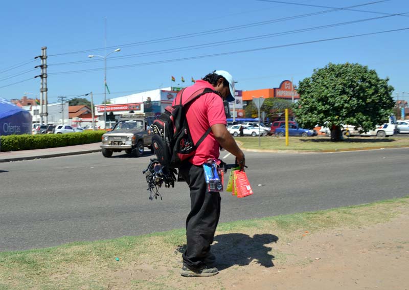 A street vendor carrying electrical accessories outside a shopping centre