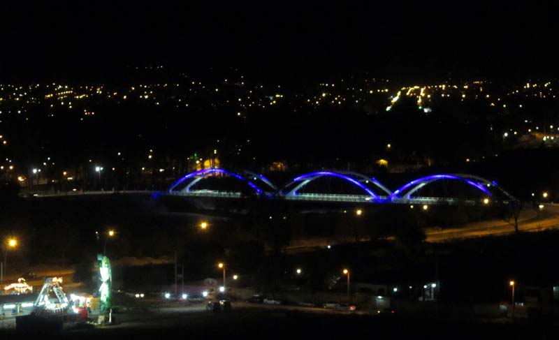 A bridge lit up at night, and other city lights
