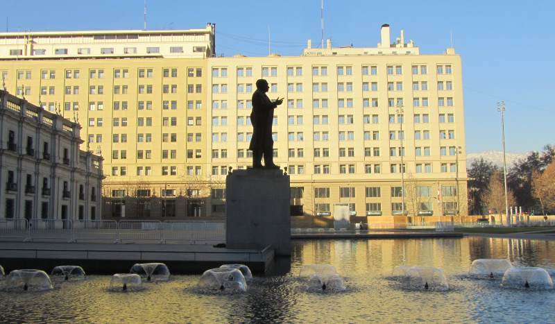 A statue silhouetted against an office block