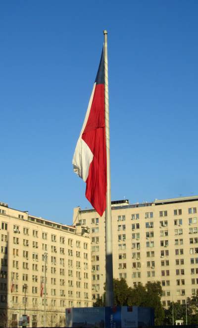A Chilean flag in front of a large office block