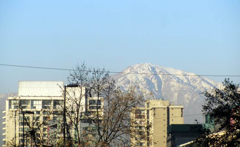 A view of the Andes behind buildings and trees