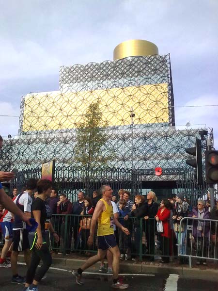 Runners walking with a new, modern building in the background