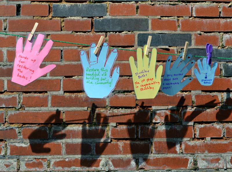 Paper cut-out hands on a line around Stirchley Baths