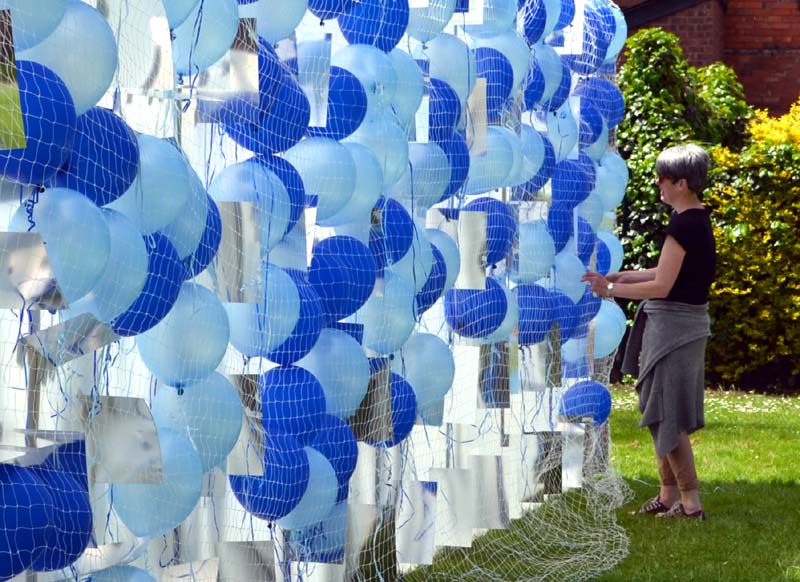 Emma places the balloons in nets on a board