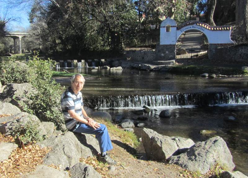 Phil sitting beside a small waterfall