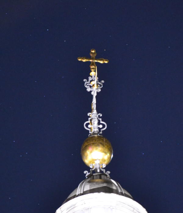 Birmingham Cathedral's newly gilded cross with a starry background