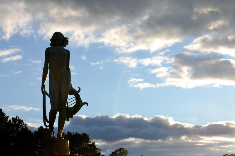 Classical statue in silhouette against the evening sky