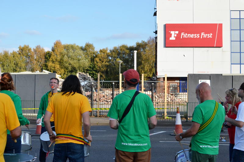 The Bloco Louco drumming group with the remains of Fitness First in the background