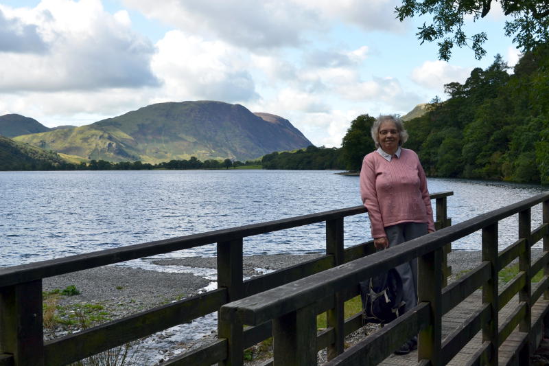 Miriam standing on a wooden bridge with Buttermere in the background