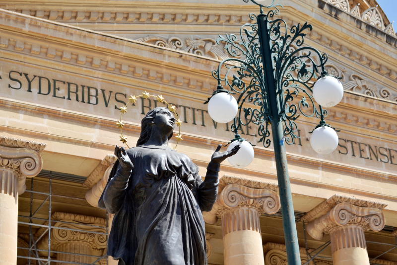 The head of a statue of Mary with the church frontage behind