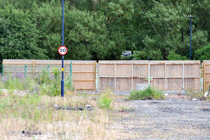 A speed limit sign on a fenced-off road