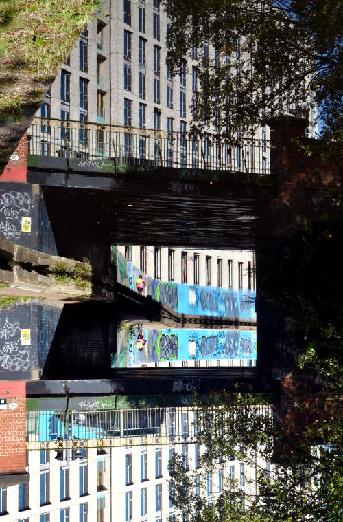 A runner goes under a road bridge with new student accommodation in the background