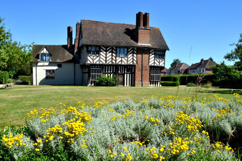 A medieval house with a flower bed in the foreground