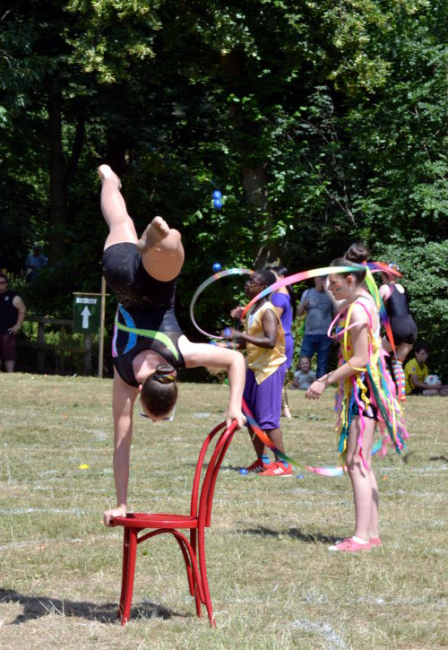 An acrobat doing a handstand on a chair