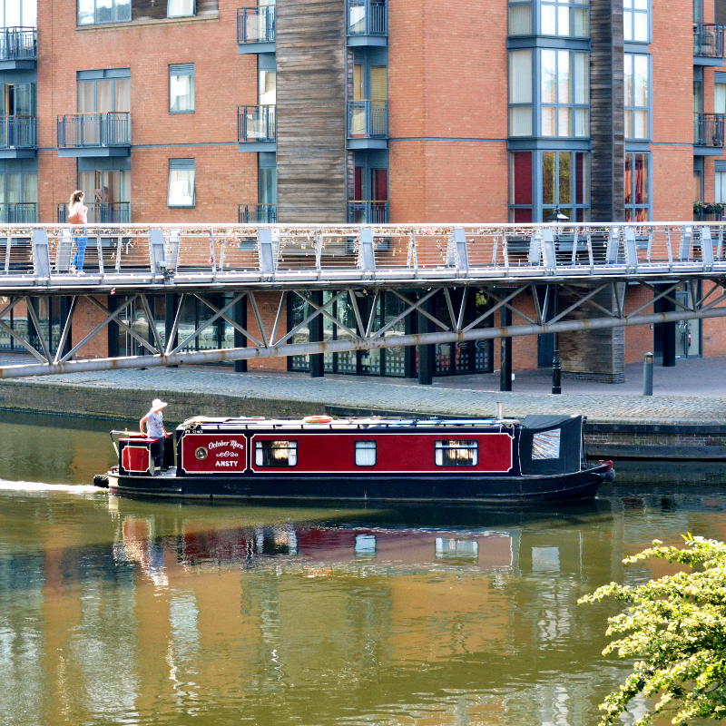 A boat passing under a pedestrian bridge