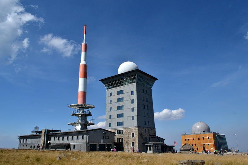 Two buildings with radomes on top, and a radio mast