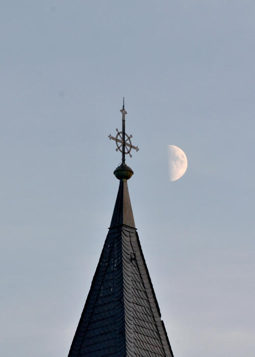 The Moon next to a church spire