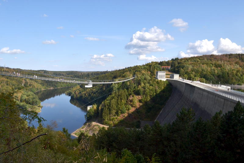 A reservoir dam with a passenger bridge alongside it