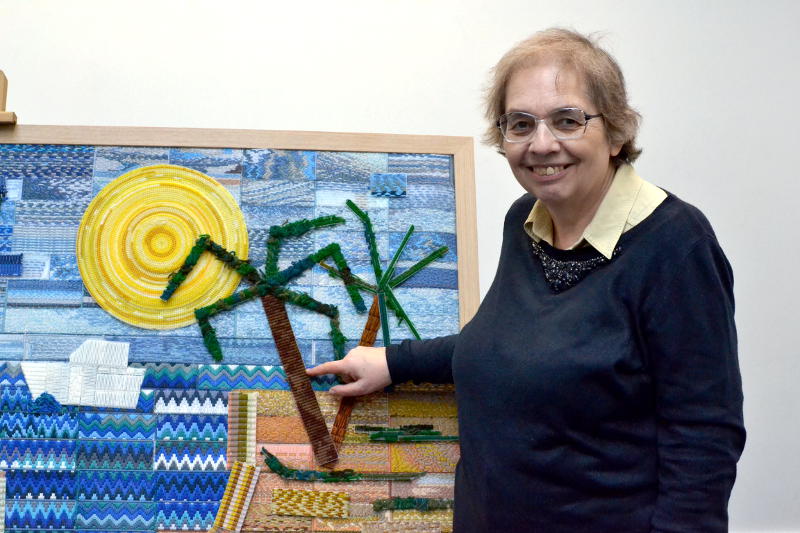 Miriam points to one of her sections of the Big Stitch tapestry