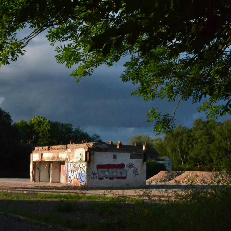 The remains of a demolished building in evening sunshine