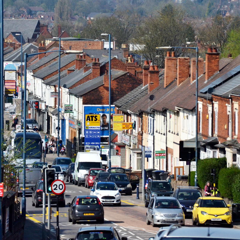 Looking down on a busy Pershore Road, with rooftops in the distance
