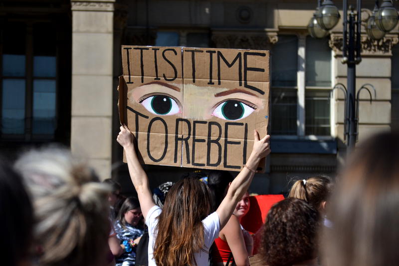 Holding up a placard: It is time to rebel