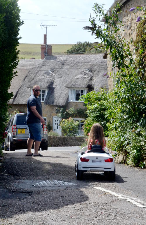 Driving an electric toy car in a village street