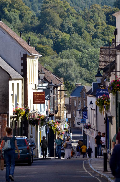 Looking along a street in Sherborne towards a wooded hill