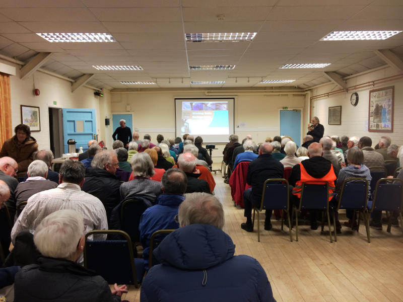 View from the back of an audience seated in a hall