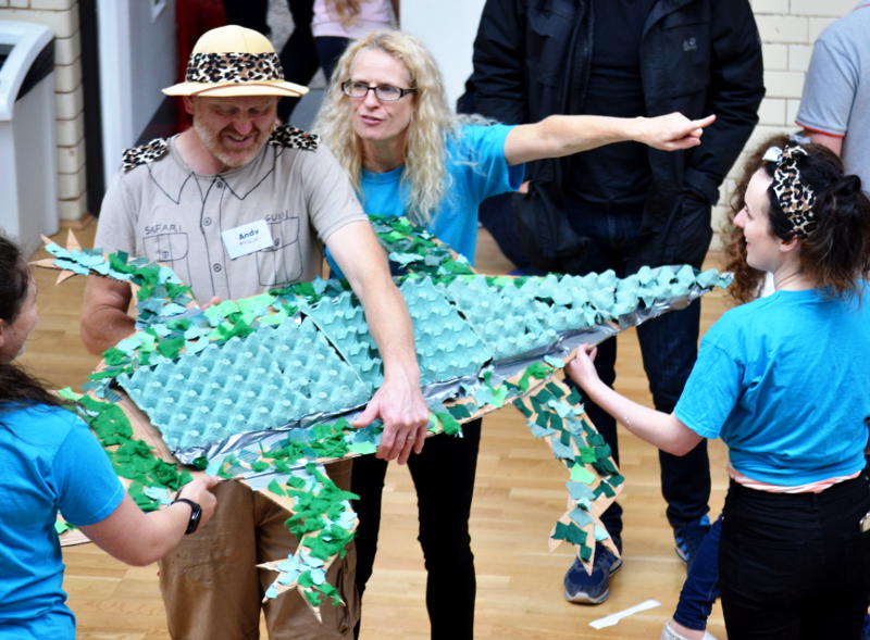 A group holding a model alligator