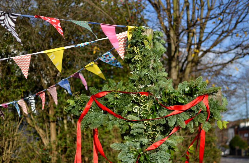 The wooden cross outside Christ Church decorated with foliage and bunting