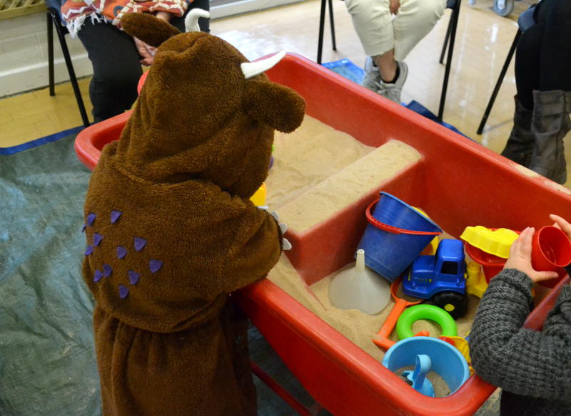 A gruffalo (costume) playing with sand