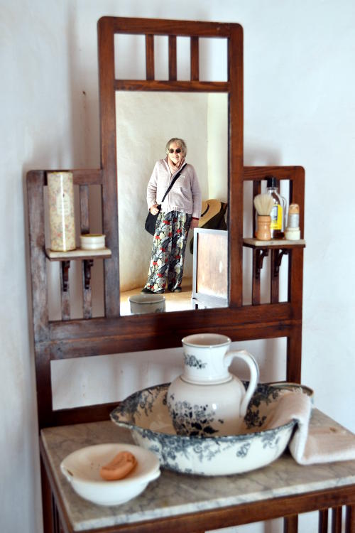 Miriam reflected in the mirror of a piece of historic furniture