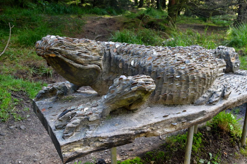 Model of a giant lizard with many coins inserted into it