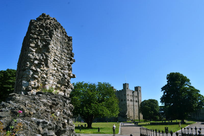 A castle with part of a stone wall in the foreground