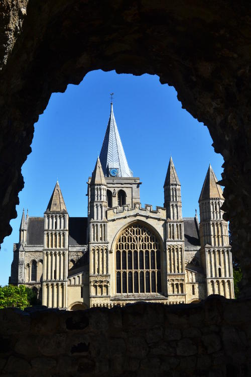 A cathedral viewed through an arched opening in a wall