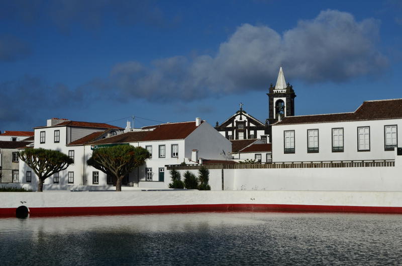 White buildings viewed across a small lake