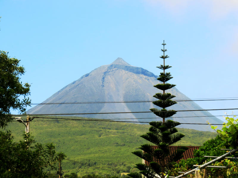 The summit of Pico mountain in sunshine, in the distance