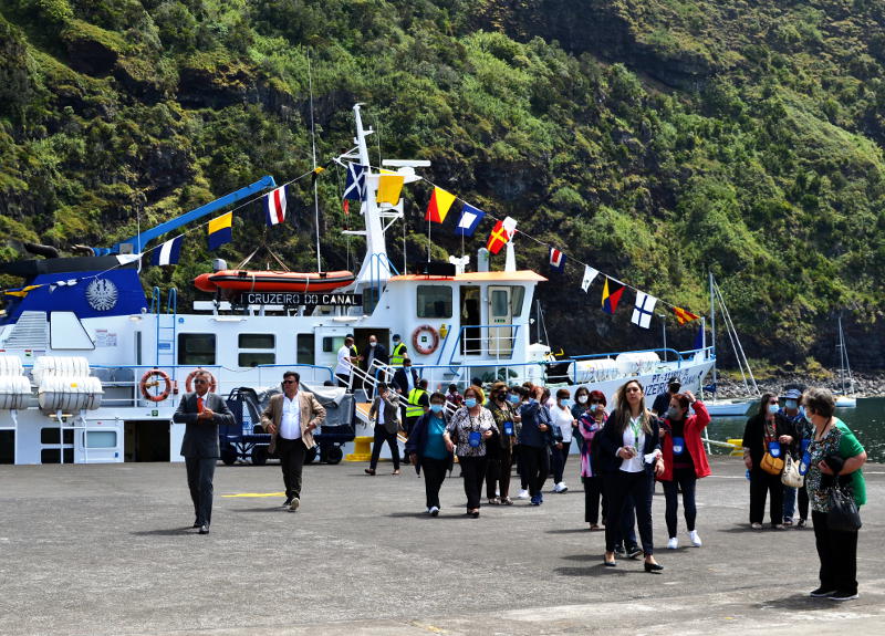 Passengers disembark from a ferry decked with bunting